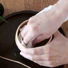 Drying the inside of a warmed matcha bowl with a clean tea towel.