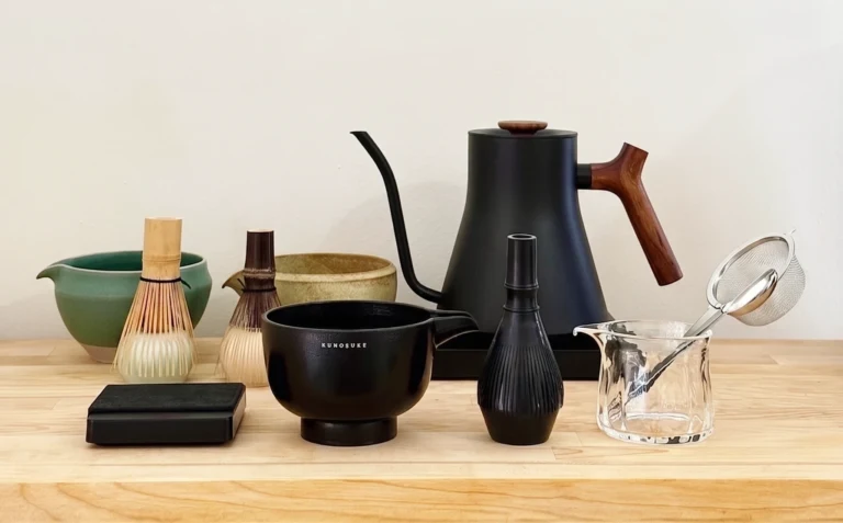 Essential matcha tools for beginners, including a chasen, chawan, chashaku, sifter, and whisk stand.